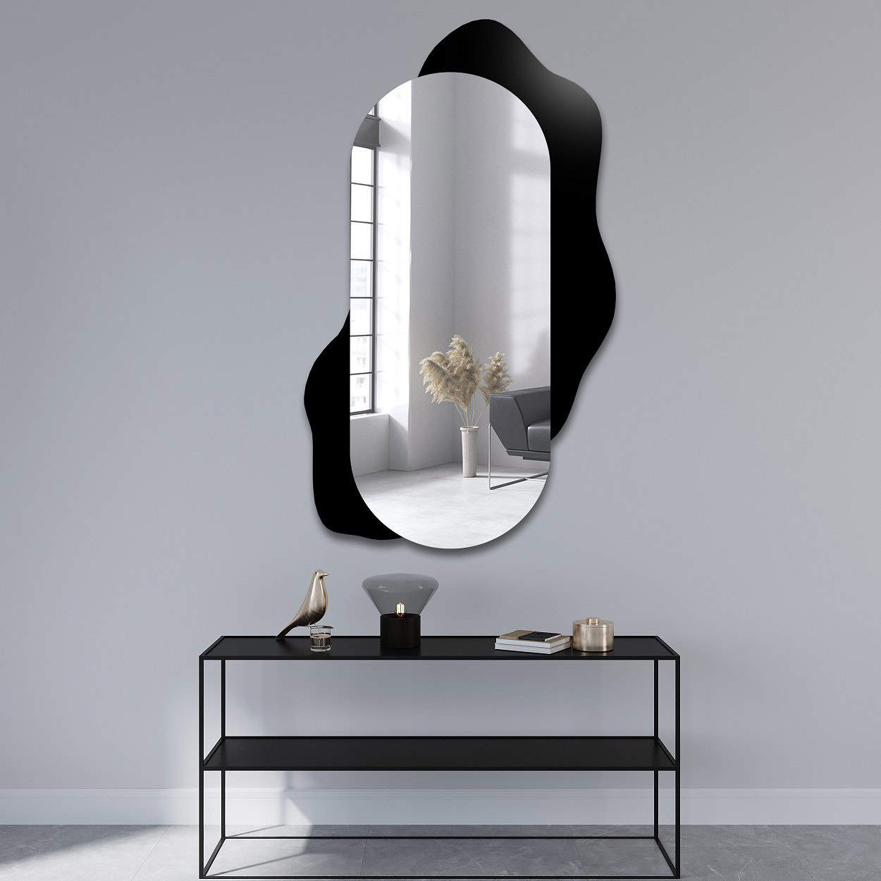 Ovale wandspiegel met een organisch gevormde zwarte achtergrond, gemonteerd in een minimalistisch interieur met een metalen console en stijlvolle decoratieve accessoires.